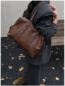 Detail of vintage brown tote bag with metal ring and strap for autumn fashion