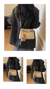 Detail of beige frosted crossbody bag featuring silver metallic twist lock and plush bear charm