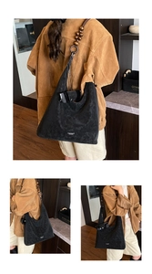 Detail of suede hobo bag featuring oversized wooden beads on the shoulder strap