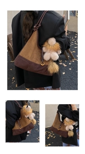 Detail of a brown suede hobo bag with a lion plush charm and brown pompom accessory