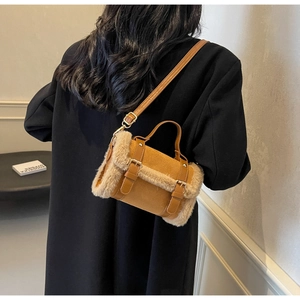 Detail of suede and plush crossbody bag featuring metal buckles and adjustable strap
