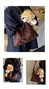 Detail of dark brown suede tote bag featuring a gold ring clasp and lion plush charm