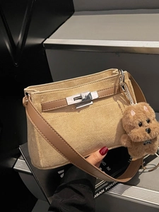 Minimalist beige suede Kelly hobo bag with leather strap and plush dog charm