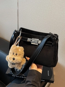 Minimalist black suede Kelly shoulder bag with silver turn-lock and dog charm