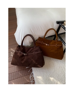 Détail des boucles de ceinture décoratives sur des sacs cabas en daim marron et café