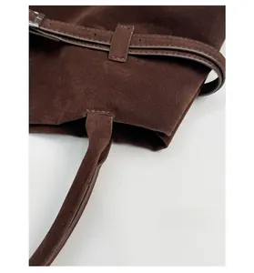 Détail de bandoulière réglable et boucle en métal sur sac cabas marron mat