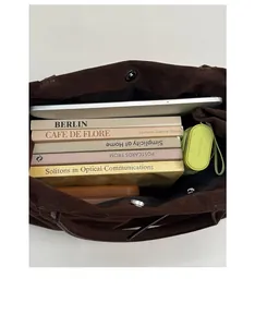 Intérieur spacieux du cabas en daim marron foncé avec ordinateur portable et livres