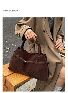 Sac cabas en daim marron foncé mat avec boucle de ceinture lors d'une séance photo
