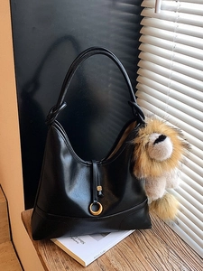 Minimalist black crescent hobo bag with gold ring detail and plush lion charm