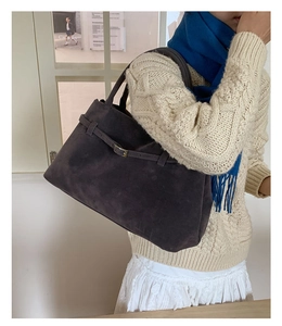 Détail du grand sac cabas gris foncé en daim avec boucle métallique sur un mannequin