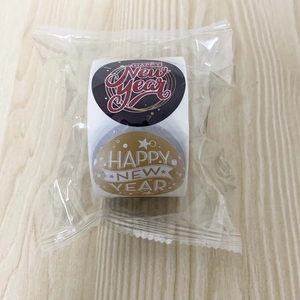 Macro shot of 1.5 inch Happy New Year roll stickers with gold and brown holiday designs