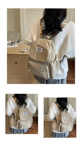 Detailed back view of khaki crinkle nylon backpack on model showing strap texture