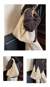 Détail d'un grand sac cabas beige minimaliste avec large bandoulière porté par un mannequin