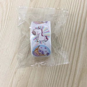 Close-up of a roll of colorful cartoon unicorn reward stickers for kids in protective wrap