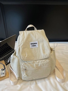 Minimalist beige nylon backpack with multi-pocket design for school and travel