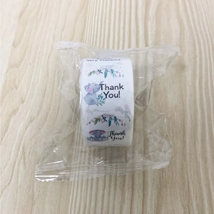Close-up of roll of round Thank You stickers with watercolor flowers and cartoon elephant
