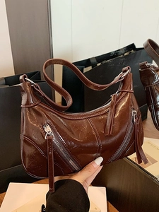 Retro brown faux leather underarm bag with decorative zippers and glossy vintage finish