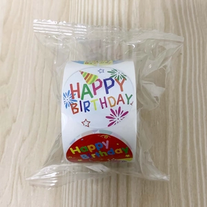 Close-up of a roll of colorful Happy Birthday label stickers in clear plastic packaging