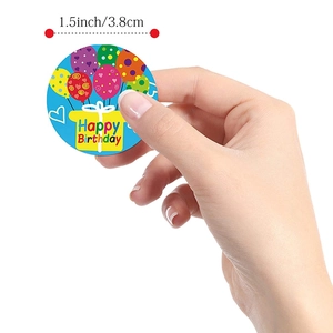 Hand holding a 1.5-inch Happy Birthday sticker with colorful balloons and gift box