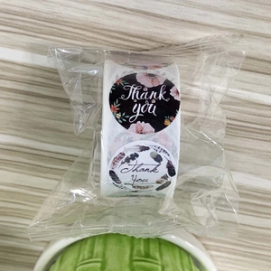 Detail of thank you adhesive stickers with floral and feather designs in plastic wrap
