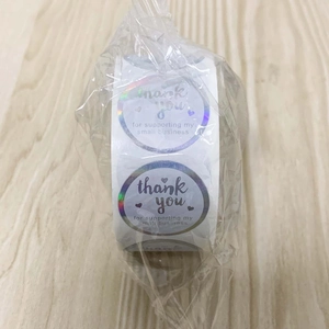 Macro shot of iridescent rainbow stickers with Thank You message for small business use
