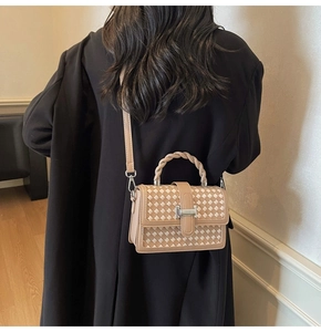 Détail d'un sac bandoulière tissé avec boucle métallique et poignée tressée torsadée