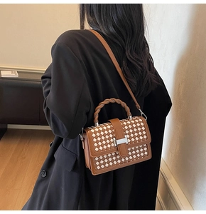 Vue détaillée du sac tissé à carreaux marron et blanc avec boucle métallique argentée en H