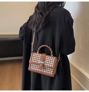 Vue détaillée du sac bandoulière à damier avec poignée torsadée porté par un mannequin