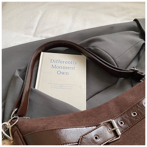 Detailed macro view of vintage brown suede shoulder bag with silver buckle and chain