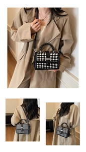 Détail du sac à carreaux avec fermoir H argenté et poignée tressée noire sur un mannequin