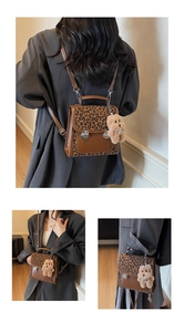 Close-up of leopard print backpack with brown leather trim and vintage silver metal clasp
