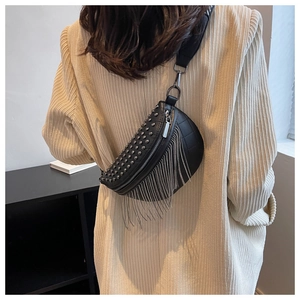 Detail of black PU leather saddle bag featuring silver metal rivets and long fringe tassels
