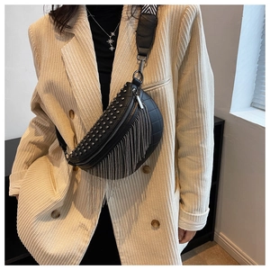 Detail of black waist bag featuring metallic studs and hanging silver chain fringe decor