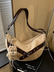 Fashionable beige suede crescent shoulder bag with leopard accent and plush dog charm