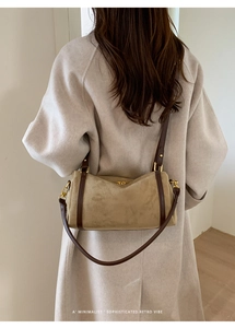 Détail du sac Boston en daim beige avec lanières en cuir marron et finitions dorées