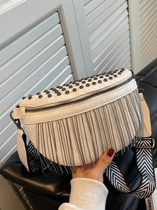 White quilted crescent saddle bag with metal rivets, tassels and wide geometric strap