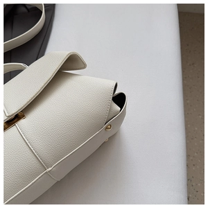 Detailed close-up of white lychee pattern leather handbag with gold metal hardware