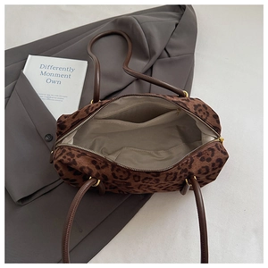 Detail view of leopard print Boston bag interior with beige lining and gold zipper