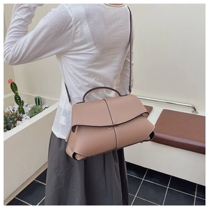 Close-up of khaki leather handbag featuring premium pebble grain and elegant fold design