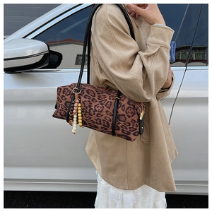 Detail of leopard print cylinder shoulder bag with bohemian beaded tassel charm