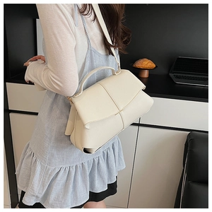 Fashionable creamy white handbag with fine leather texture shown on a model's arm