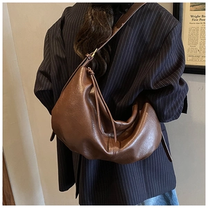 Detail of adjustable knotted strap and soft dark brown leather on hobo shoulder bag