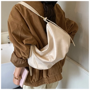 Model wearing off-white large capacity half-moon tote bag with adjustable shoulder strap