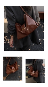 Détail d'un sac cabas en cuir marron foncé brillant avec boucle en croissant doré