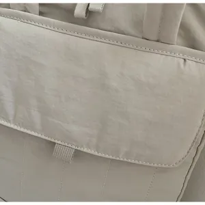 Detail of khaki commuter tote bag showing quilted texture and front flap pocket