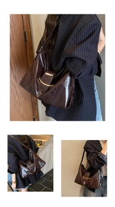 Détail du sac cabas en cuir marron foncé avec boucle métallique dorée courbée