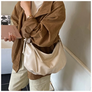 Close-up of cream soft leather tote bag featuring elegant drawstring side details