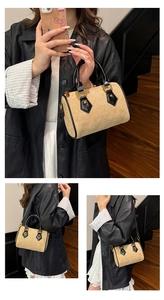 Detail showing the quilted suede texture and gold hardware of the Boston bag