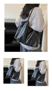 Detail of glossy black leather tote bag with metal chain strap and soft texture finish