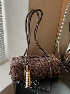 Vintage leopard print cylindrical handbag with slim shoulder straps and bead charm detail